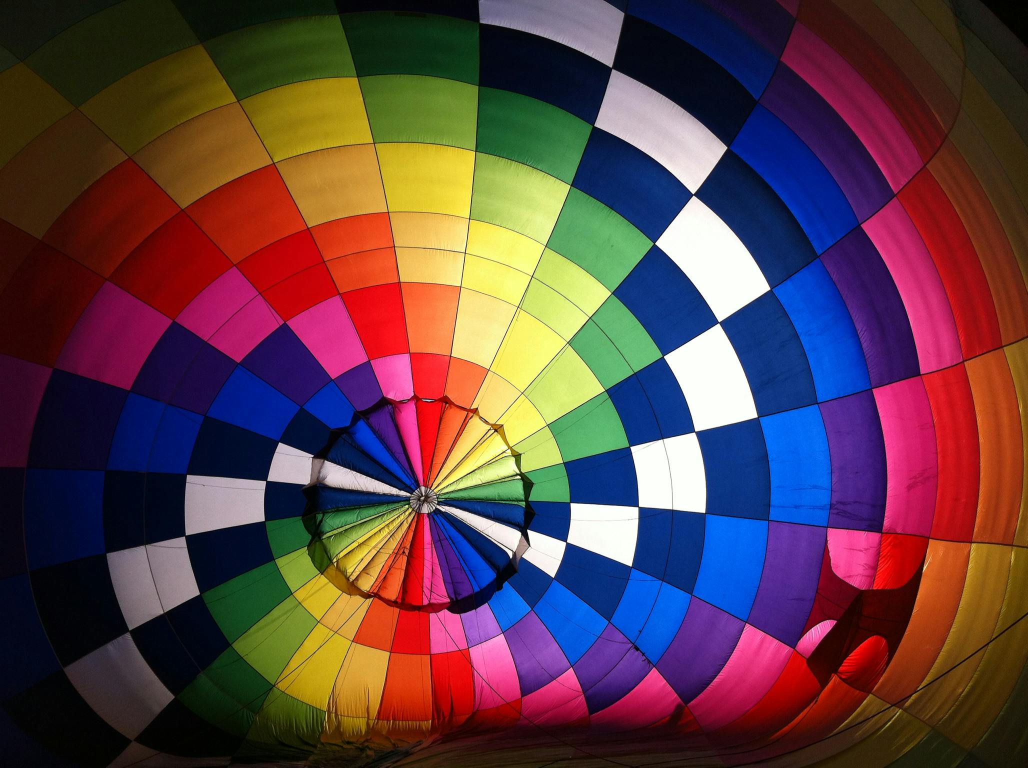 Vibrant interior shot of a colorful hot air balloon, showcasing its rainbow pattern and design.